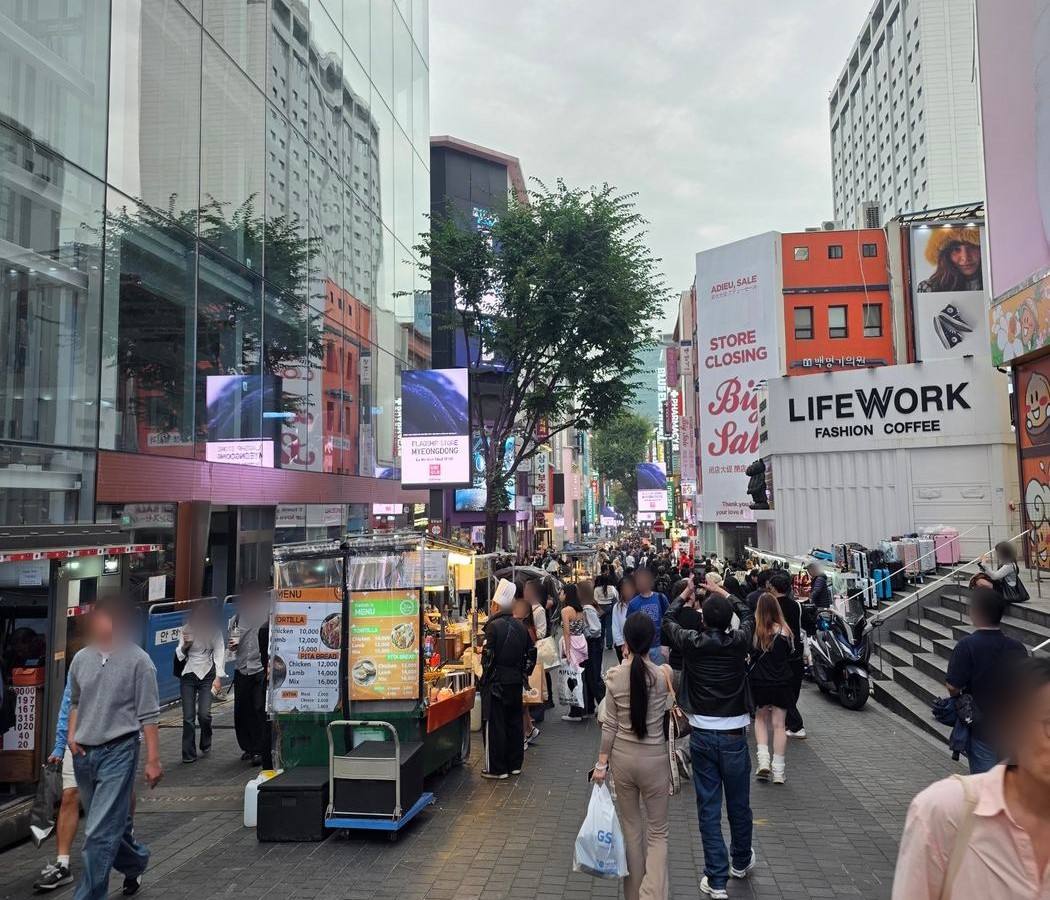 명동 중앙로, 오후. 거리 끝까지 사람이 이어집니다.