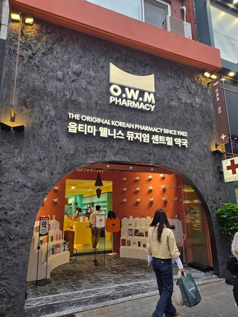 거친 질감의 짙은 회색 외벽에 아치형 입구를 낸 O.W.M PHARMACY. ‘THE ORIGINAL KOREAN PHARMACY SINCE 1982’ 문구가 눈에 띕니다. 주황 벽면에 약사발을 장식으로 배치했고, 매장 안쪽은 노랑과 민트색 진열장으로 꾸몄습니다.